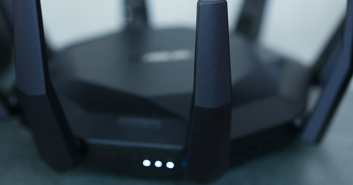 Close-up of a Wi-Fi router with multiple antennas and glowing blue status lights